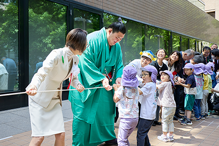 力を合わせてロープを引っ張る子どもたちと大人の参加者